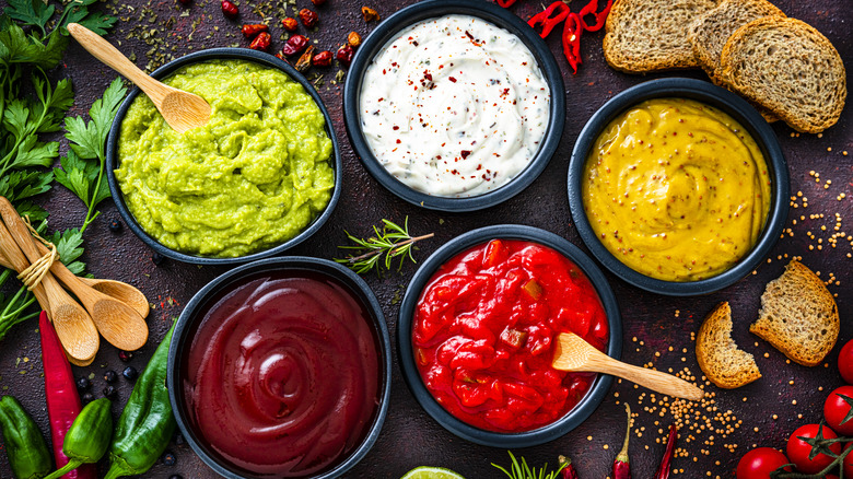 Five different bowls containing various condiments.