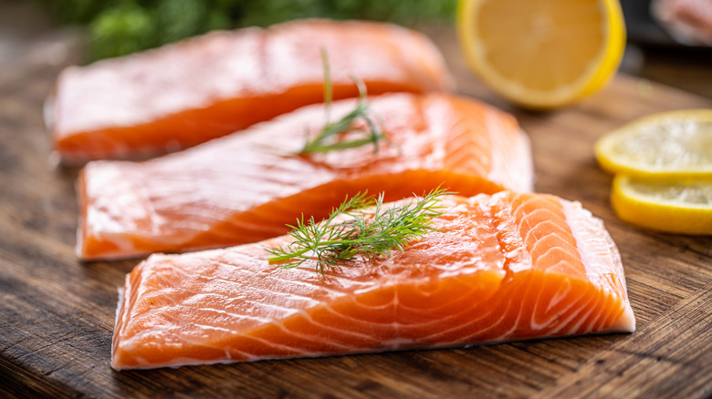 Uncooked salmon filets on a cutting board.