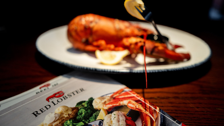 Red Lobster menu with a plate of lobster in the background