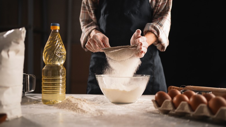 Person sifting flour into bowl