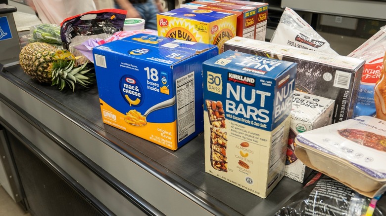 Various grocery items on a checkout conveyor belt at Costco.