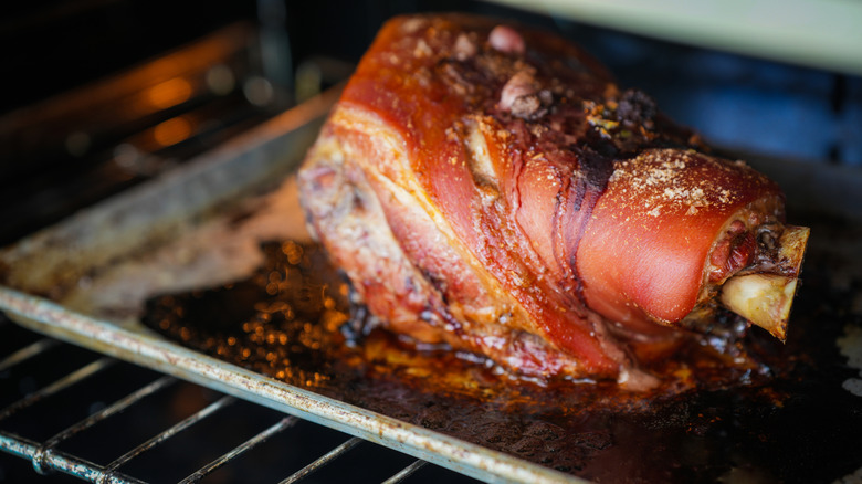 Pernil roasting on sheet pan in oven