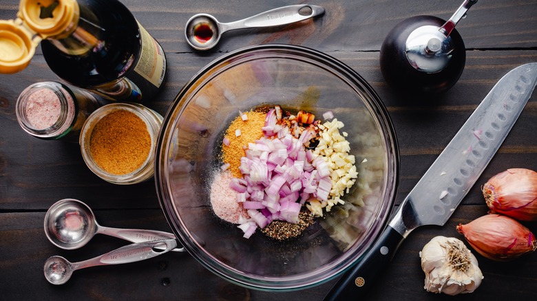 Ingredients for a marinade in bowl and in bottles around bowl
