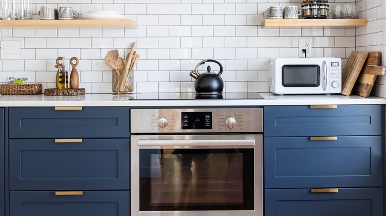 Blue and white kitchen with oven and microwave