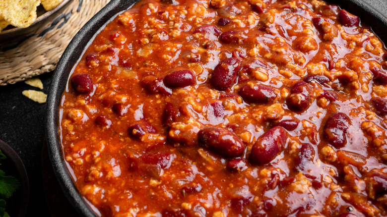 A bowl of chili heavy with tomatoes photographed in close-up