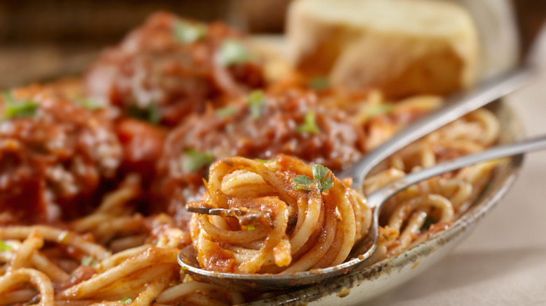 Spaghetti on a spoon covered in marinara sauce