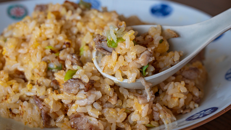Chinese style fried rice with egg vegetables and shrimp served on plate as Asian meal closeup