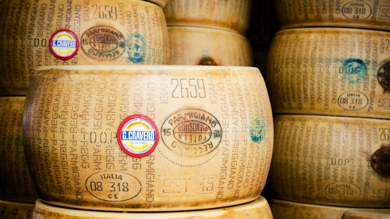 Large wheels of Parmesan cheese stacked on each other.