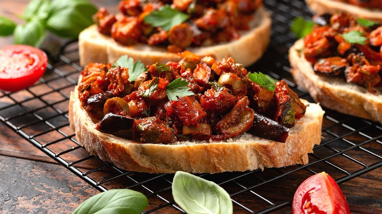 Caponata on small rounds of Italian bread on a wire rack