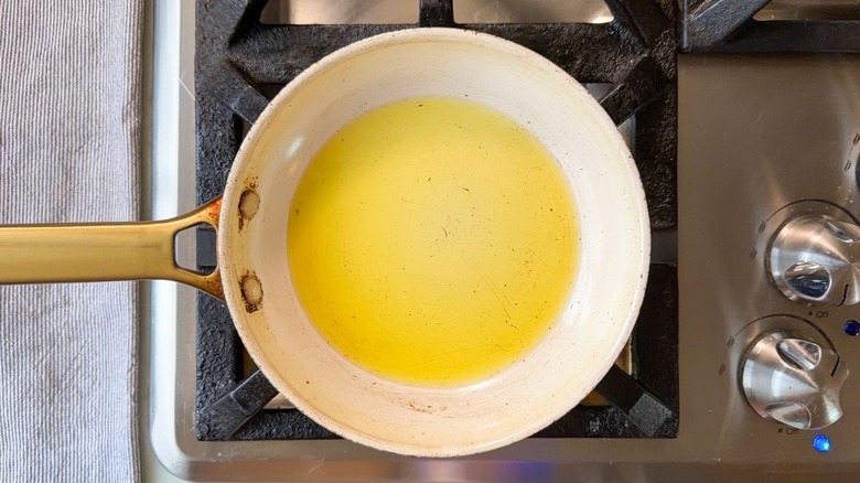 Olive oil heating in small skillet on stovetop