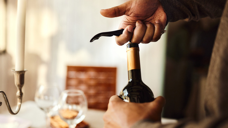 Opening wine with corkscrew