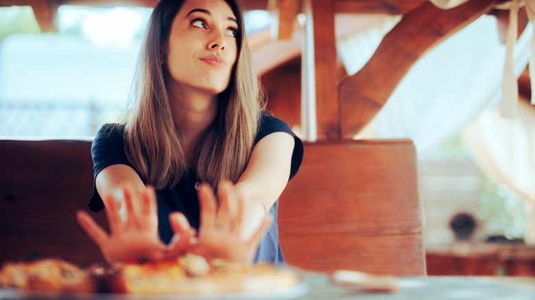 A customer pushing away a plate of food
