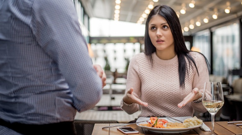 An unhappy restaurant customer speaking to a server