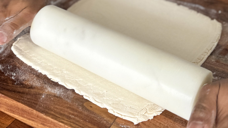 Rolling out puff pastry with a marble rolling pin.
