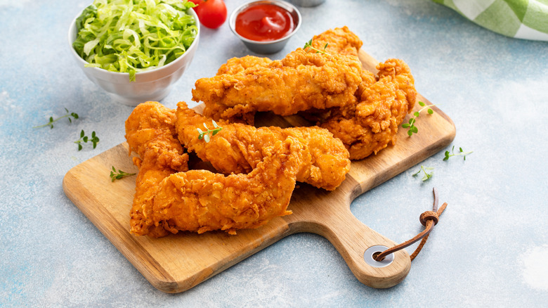 Chicken tenders on wooden board