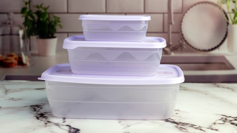A stack of 3 plastic containers on a kitchen counter.