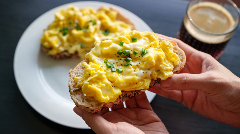creamy scrambled eggs on toast garnished with green onion