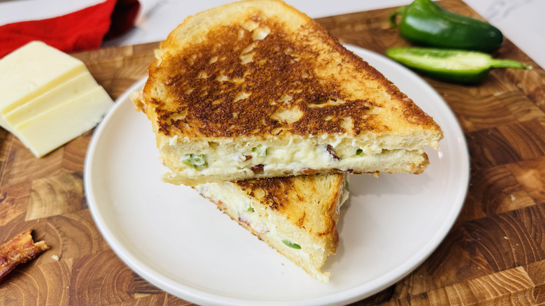 Halved jalapeño popper grilled cheese sandwich on plate