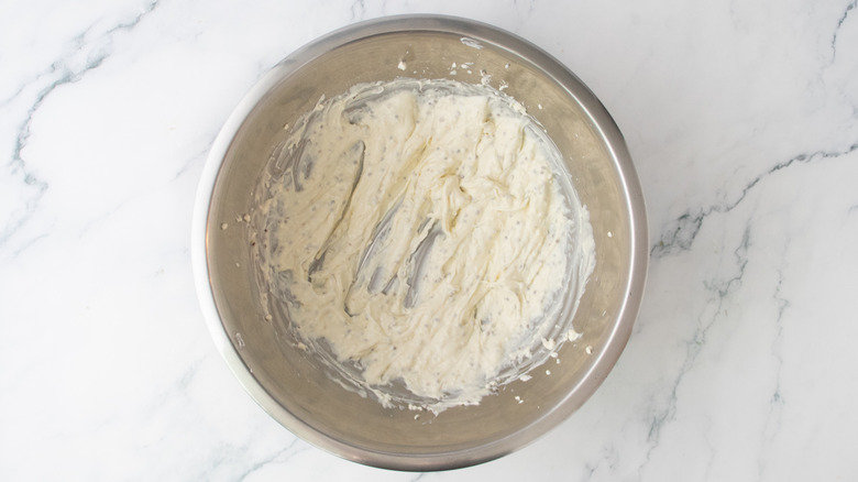 A creamy dressing in a large metal bowl