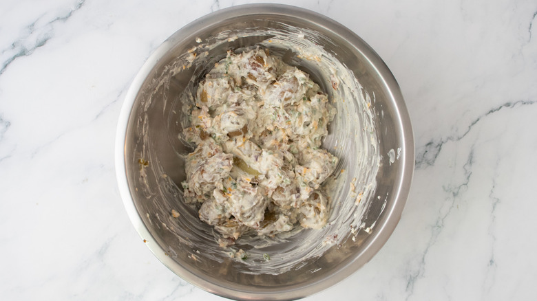 A composed potato salad in a large metal bowl
