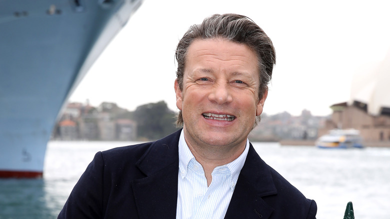 Jamie Oliver posing in front of a ship