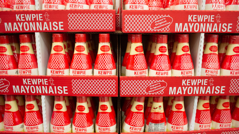 row of kewpie mayonnaise bottles on a grocery store shelf