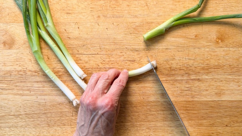 Trimming scallions on a cutting board