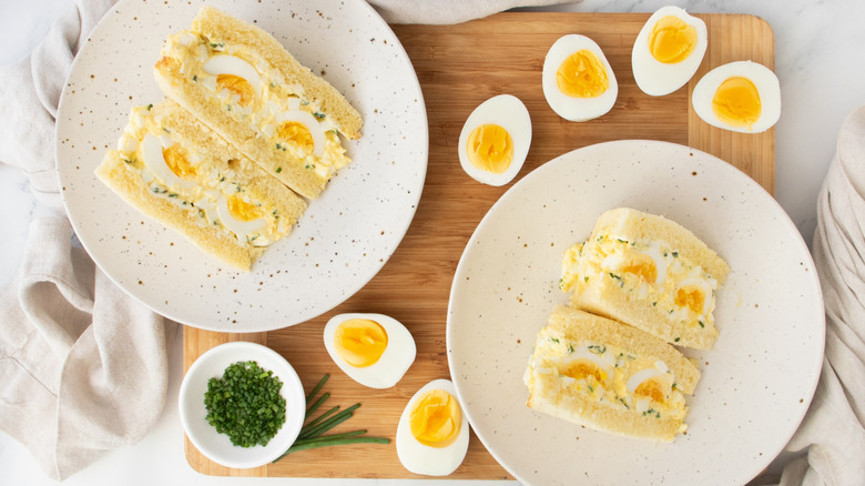 Overhead shot of two egg salad sandwiches and hard boiled eggs