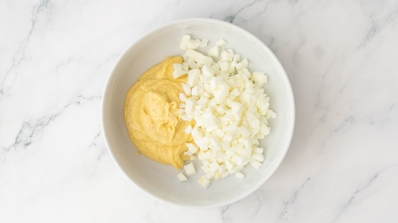 A white bowl with creamy egg yolk puree and chopped egg whites.