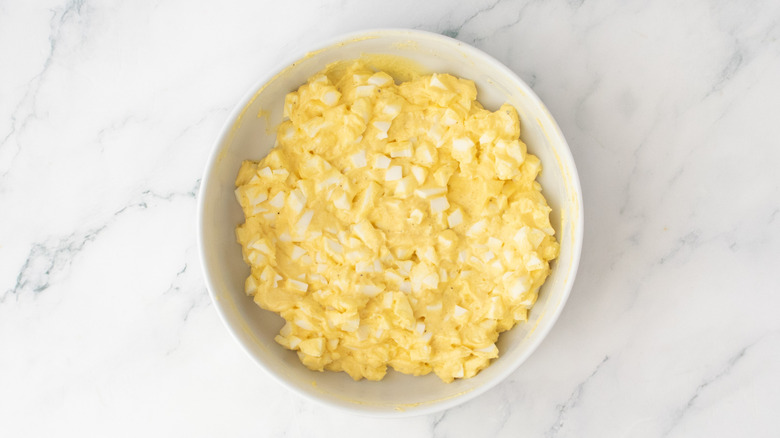 A white bowl containing egg salad.