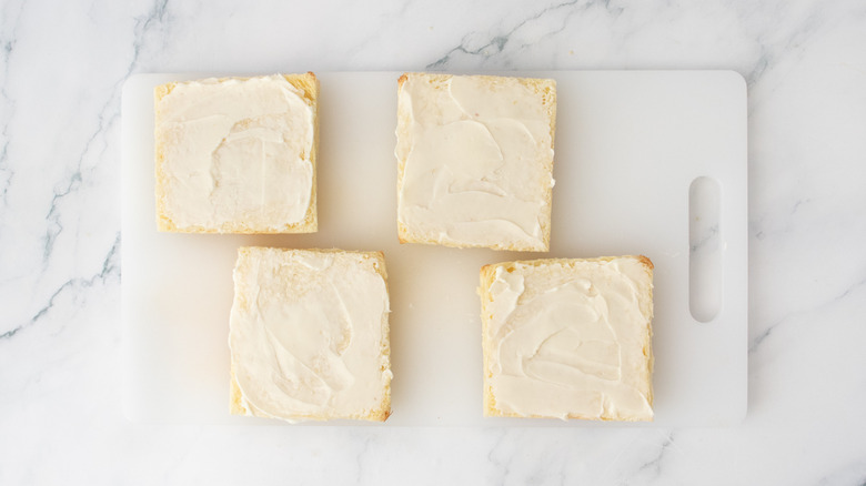 Crustless bread slices spread with softened butter