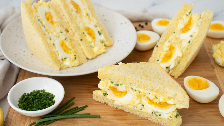 Side shot of egg salad sandwiches and hard boiled eggs