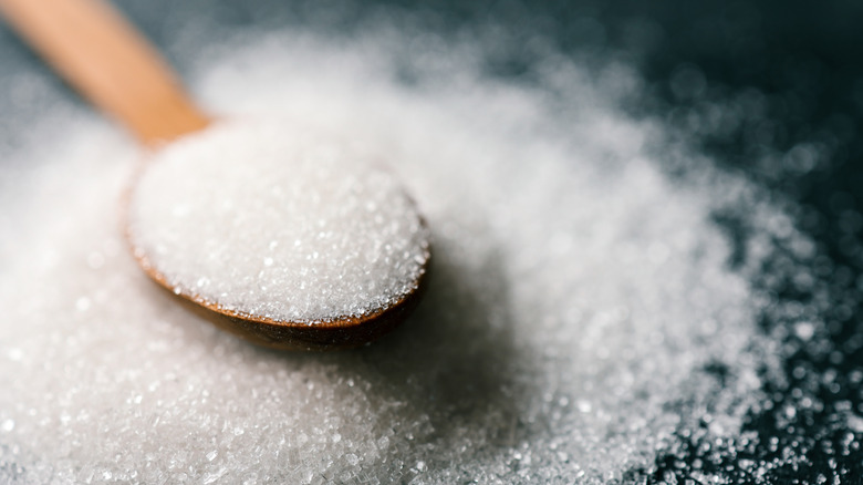 a wooden spoon holding sugar