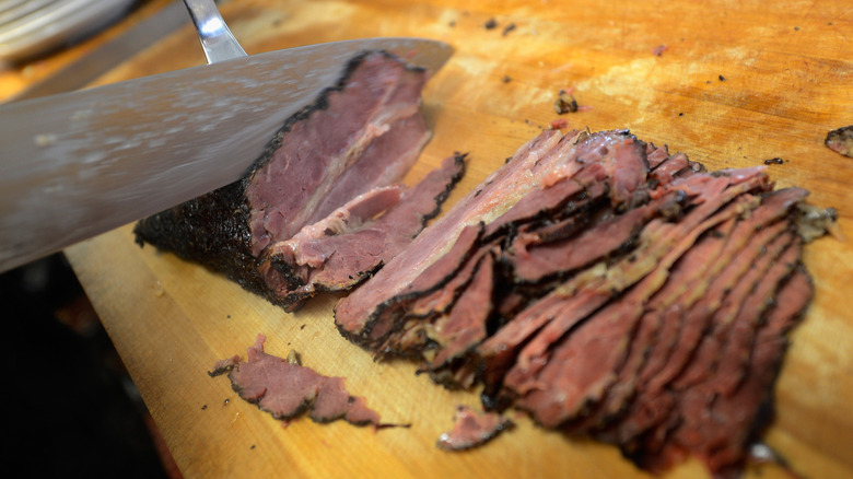 An employee at Langer's Delicatessen hand-slices pastrami.