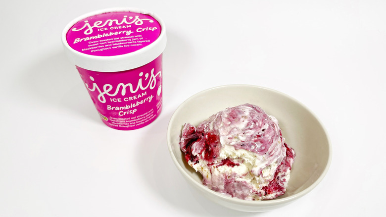 A pint of Jeni's Brambleberry Crisp next to a bowl of ice cream