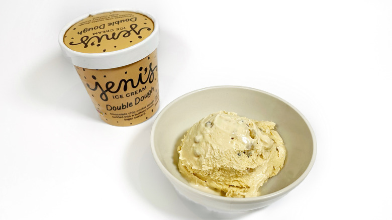 A pint of Jeni's Double Dough next to a bowl with ice cream