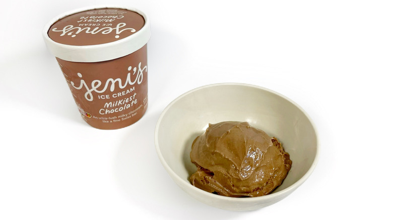 A pint of Jeni's Milkiest Chocolate next to a bowl of ice cream