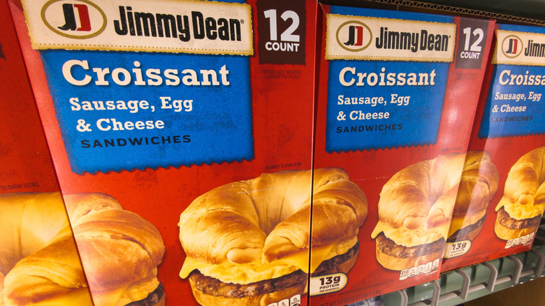 Boxes of Jimmy Dean croissant, sausage, egg, and cheese sandwiches in a freezer case