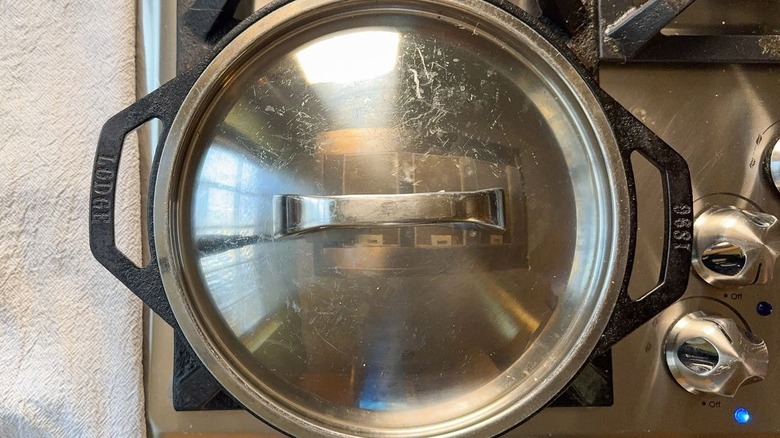 Covered cast iron skillet on stovetop