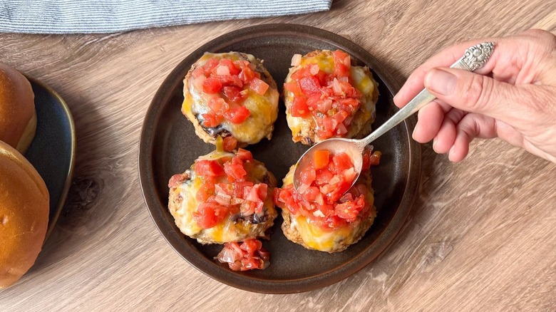 Topping juicy 3-ingredient tex-mex turkey burgers with salsa on serving platter