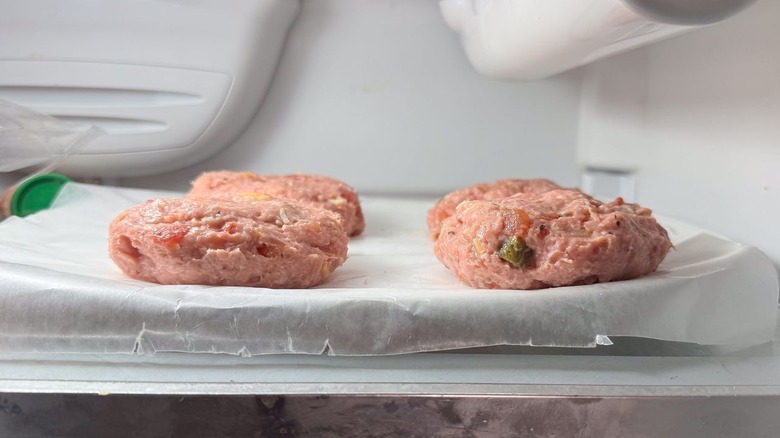 3-ingredient tex-mex turkey burgers on waxed paper on platter in refrigerator