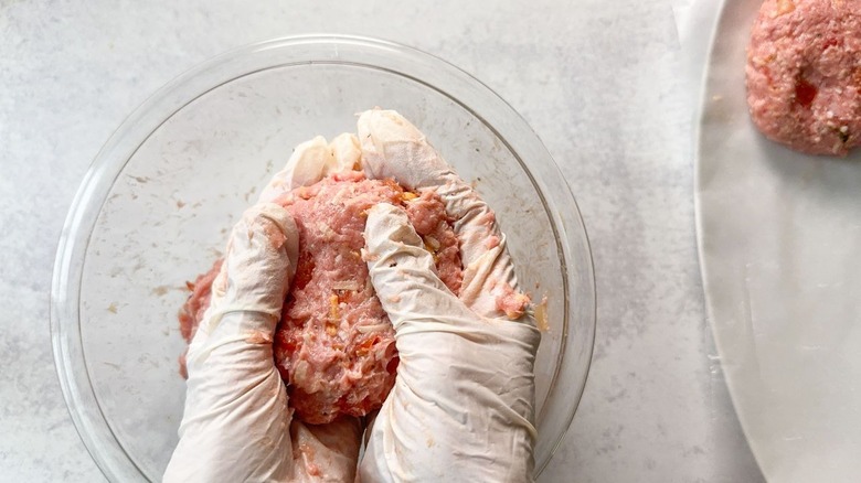 Shaping turkey burger patties by hand with gloves