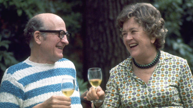 Julia Child and Paul Child smiling and holding drink glasses