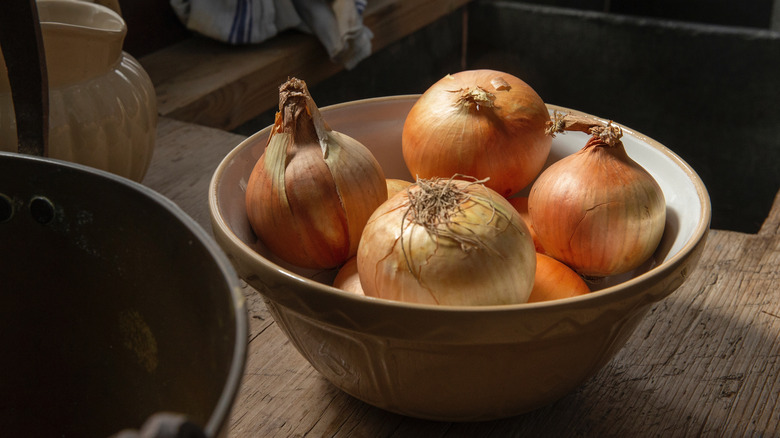 Onions in a bowl on wooden counter