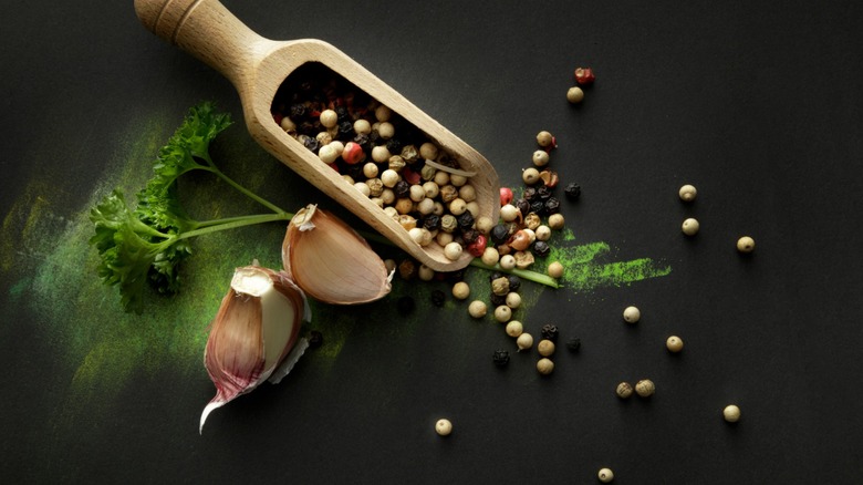 Cloves of garlic with a scoop of pepper grounds