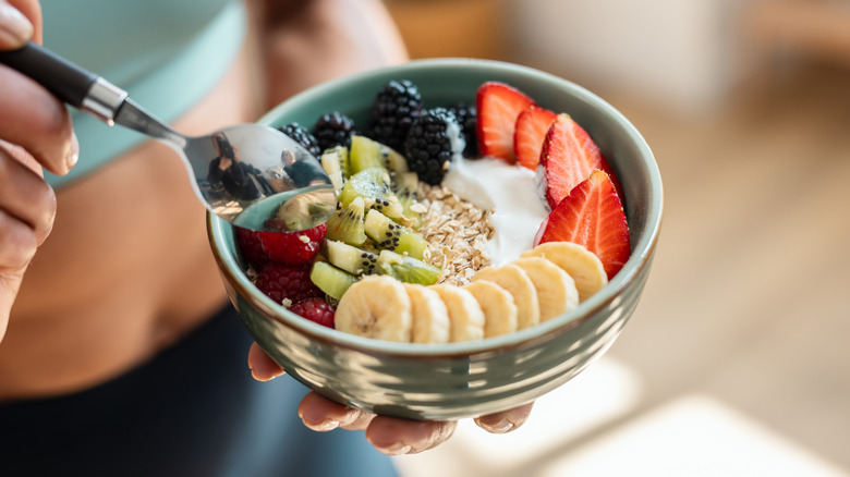 Person with a spoon in a yogurt bowl