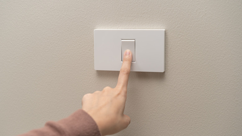 Person touching a kitchen light switch