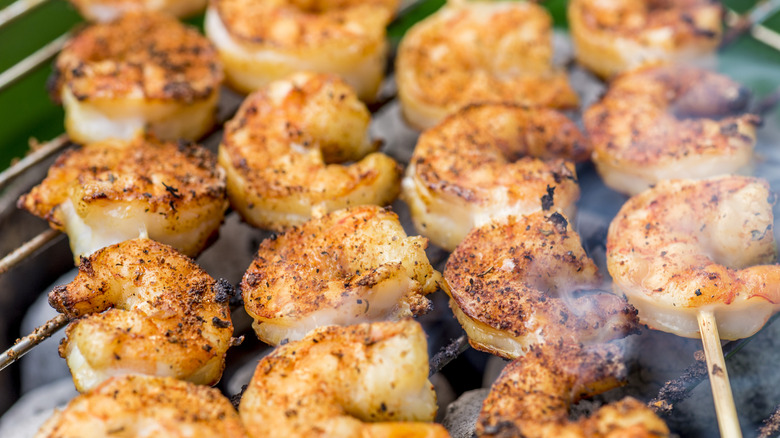 A close-up image of skewered shrimp on a grill.