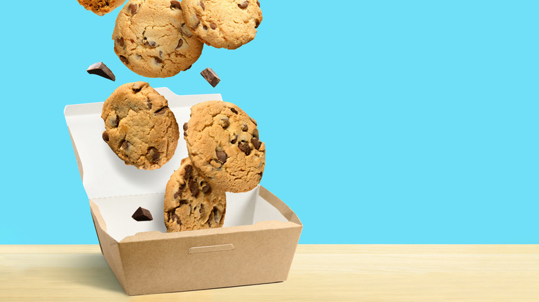 chocolate chip cookies falling into box