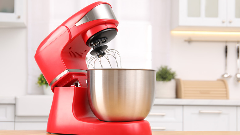red stand mixer on a wooden counter